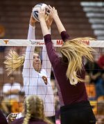 Volleyball joust Texas block and Texas A and M over the net