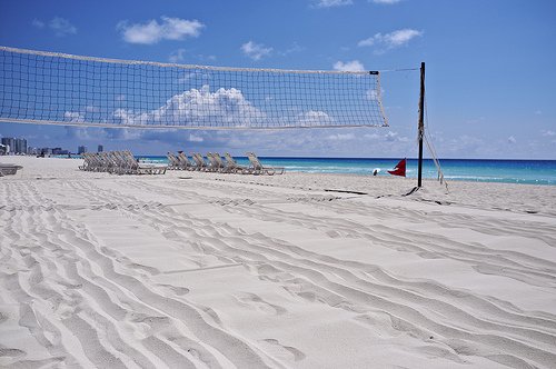 In 2001, in a controversial move the FIVB voted to minimize the volleyball court size for outdoor doubles sand competition to a much shorter size of 8 meters by 16 meters for men and women.  (beach volleyball court on the beach court photos by leonardli)