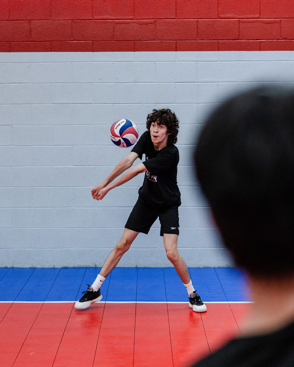 A volleyball passing platform is with forearms clasping your thumbs together and pointing them to the ground so ball contacts above wrists and below elbows.  