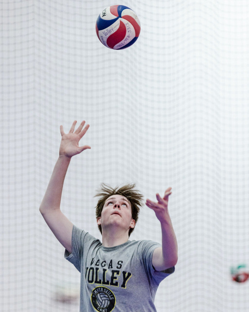 The volleyball toss for the overhand serve needs to consistently be two feet up in the air and one foot in front of front foot which puts the ball in front of your serving arm. 