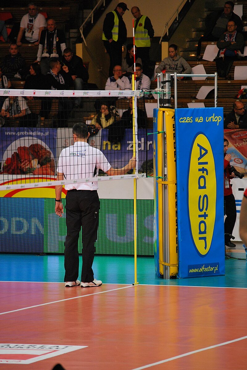 Volleyball referee job is to Measure the net (photo by zorro2212)